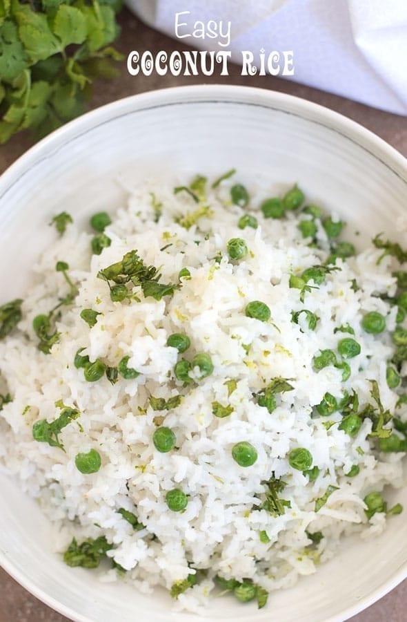 Overhead view of a white bowl with coconut rice and peas