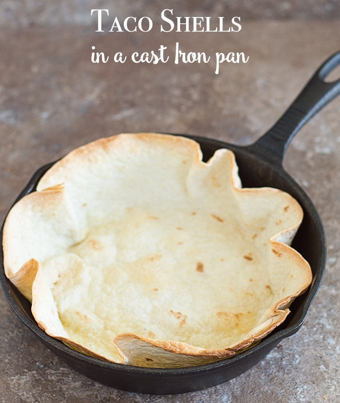 Overhead view of a tortilla bowl baked in a cast iron skillet - Make Taco bowls in a cake pan