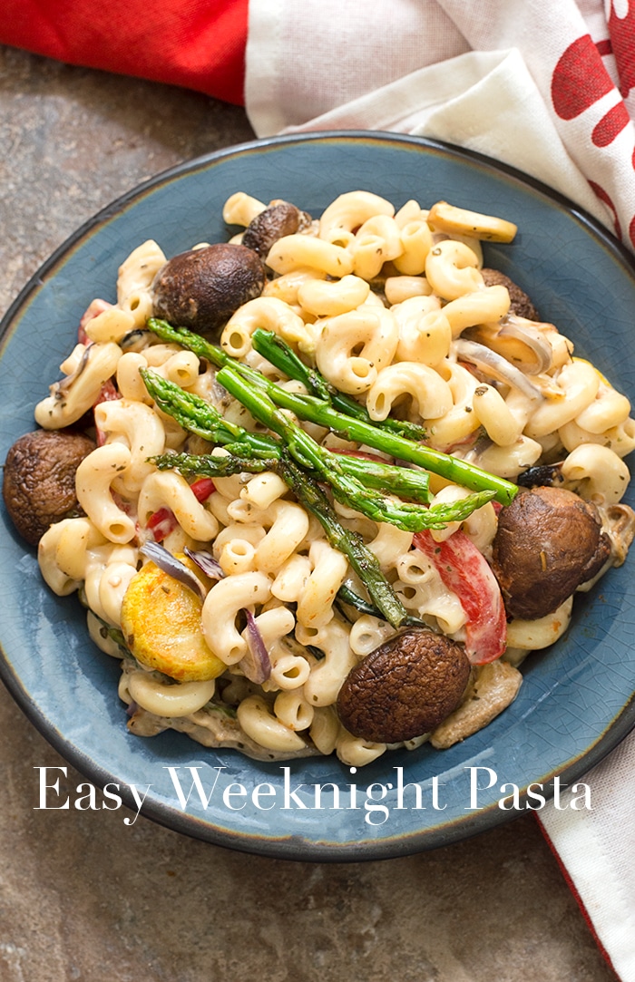 Overhead Shot of Cooked Elbow Pasta in a Dark Blue plate with Cooked Asparagus, Button Mushrooms, Bell Peppers and Squash in the Photo - Easy Weeknight Pasta