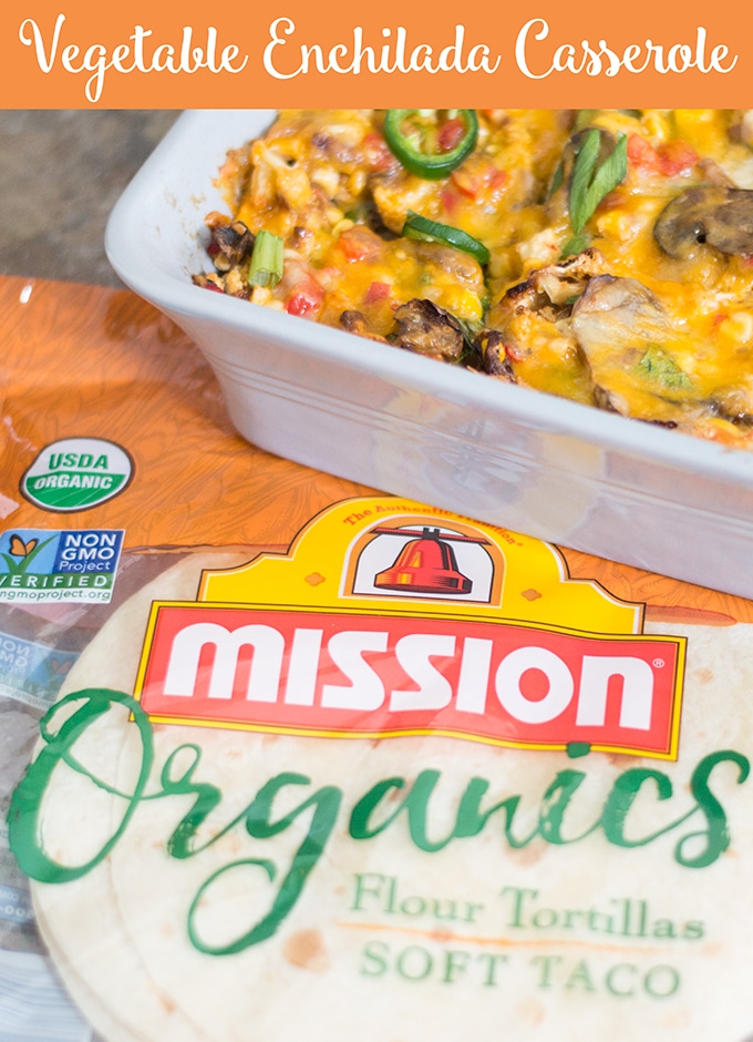A Packet of Mission Organics Soft Flour Tortillas is Placed Flat on a Tile. On the Top Right of the Image, Part of a Cheesy Vegetarian Enchilada Casserole is Visible