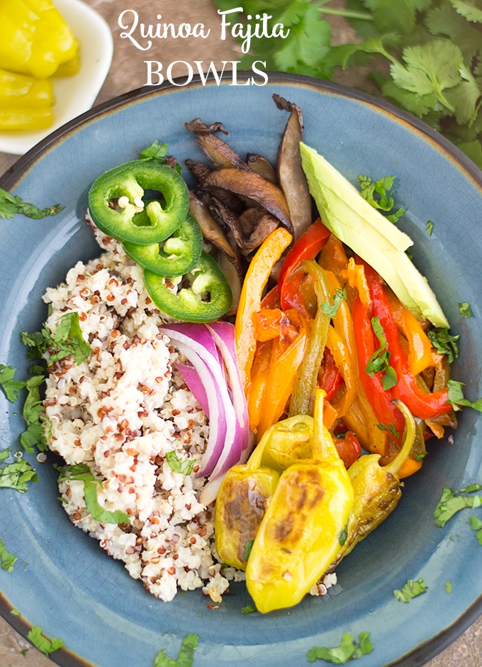 Overhead View of A Dark Blue Plate Filled With Quinoa on the Left. On the Right, There are Cooked Red Bell Peppers, Mushrooms, Peperoncini, Red Onions and Jalapeno. Garnished with Chopped Cilantro. Quinoa Fajita Bowls