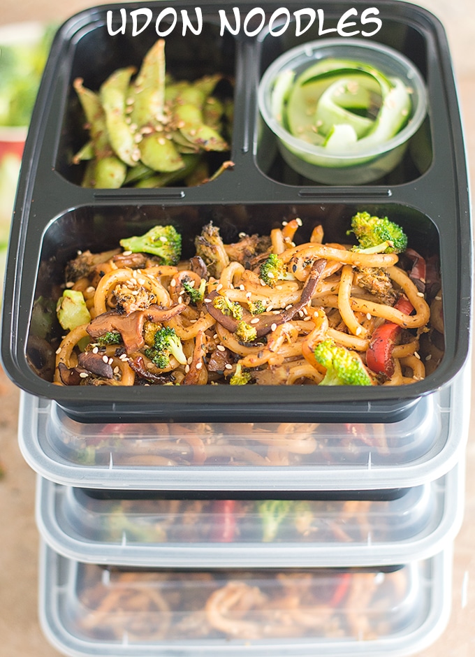 4 Plastic Meal Prep Containers filled with the Udon Noodles Stir Fry Stacked on top of each other