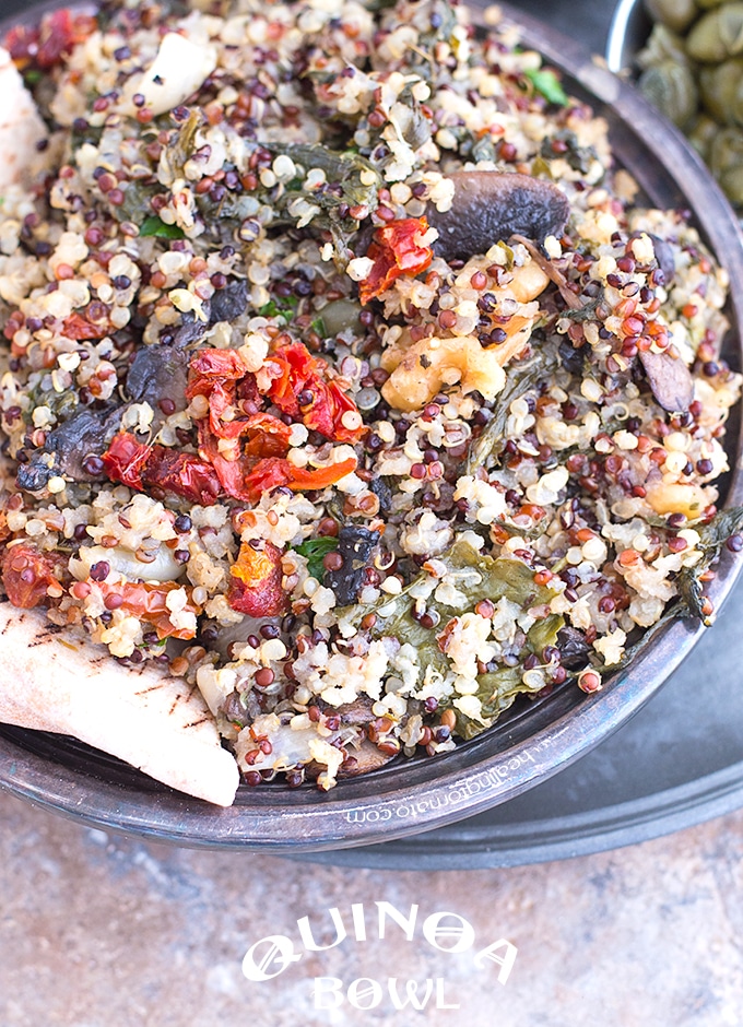 Closeup View of a Rustic Bowl Filled with Cooked Quinoa, Mushrooms, Sundried Tomatoes, Kale and Walnuts