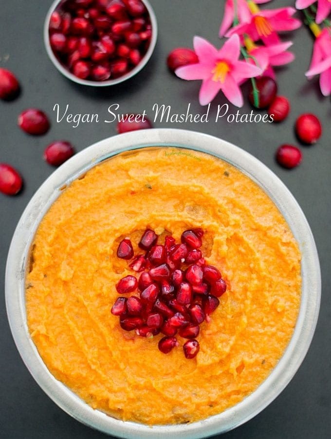 Overrhead view of a steel bowl with vegan mashed sweet potato with pomegranate in the middle