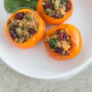 Three Stuffed Persimmons on a white plate with spinach leaves