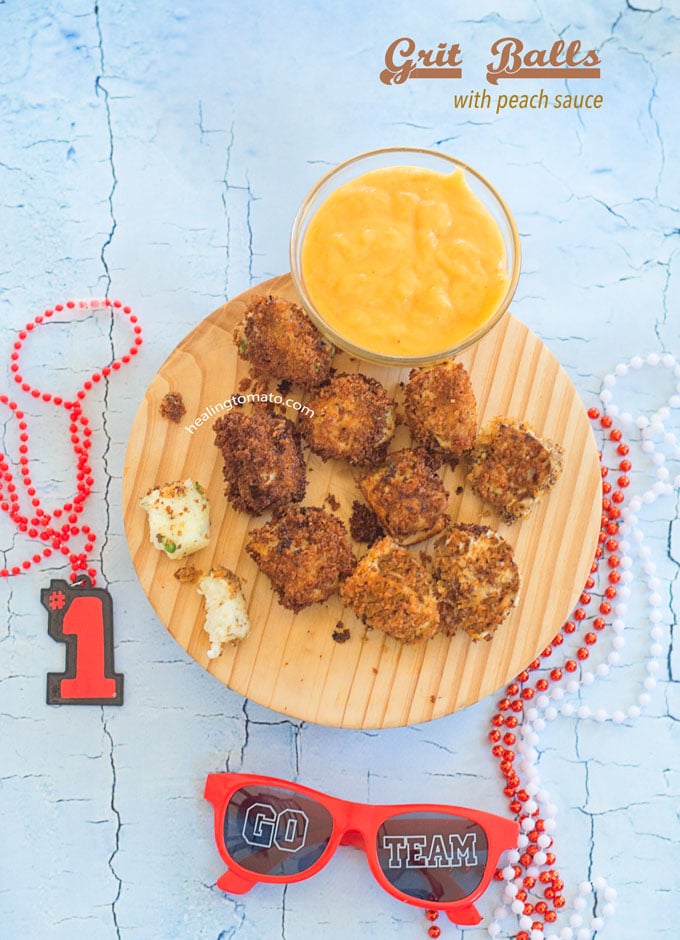 Overhead View of Grit Balls on a Brown Board with a Peach Sauce in a Small Bowl on the Side