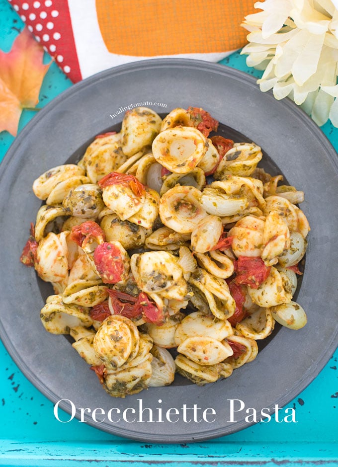 Closeup view of a grey plate filled with Vegan Orecchiette Pasta, roasted tomatoes and pearl onions