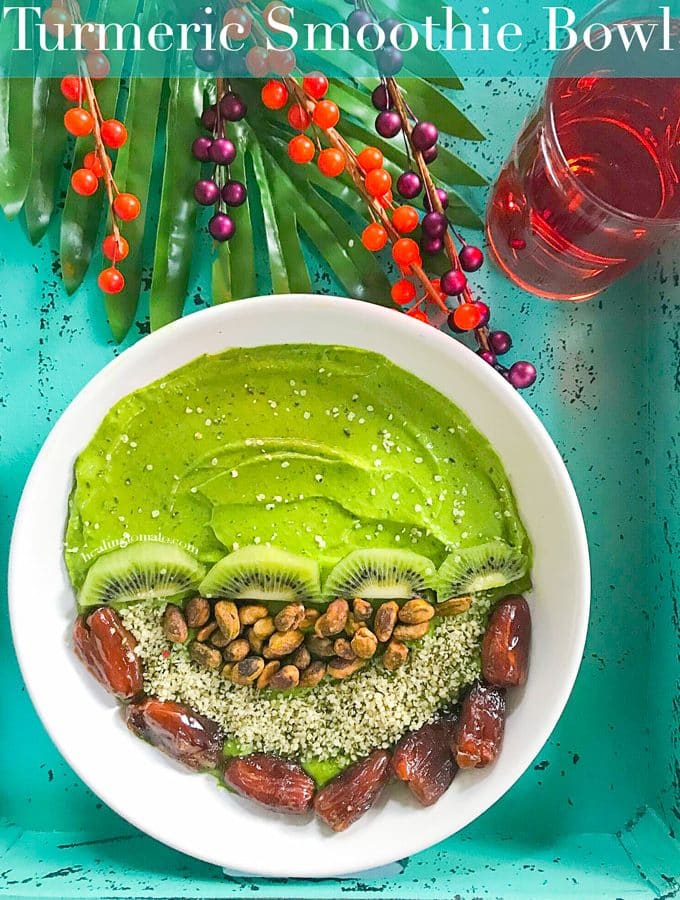 Overhead View of a Turmeric Smoothie Bowl with Green Smoothie on one half. The other half has Kiwi, Pistachios, Dates and Hemp Seeds