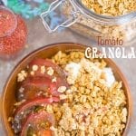 Overhead of a brown bowl filled with the tomato granola with the kombucha dressing in the glass bottle. A mason jar with the Granola is next to it
