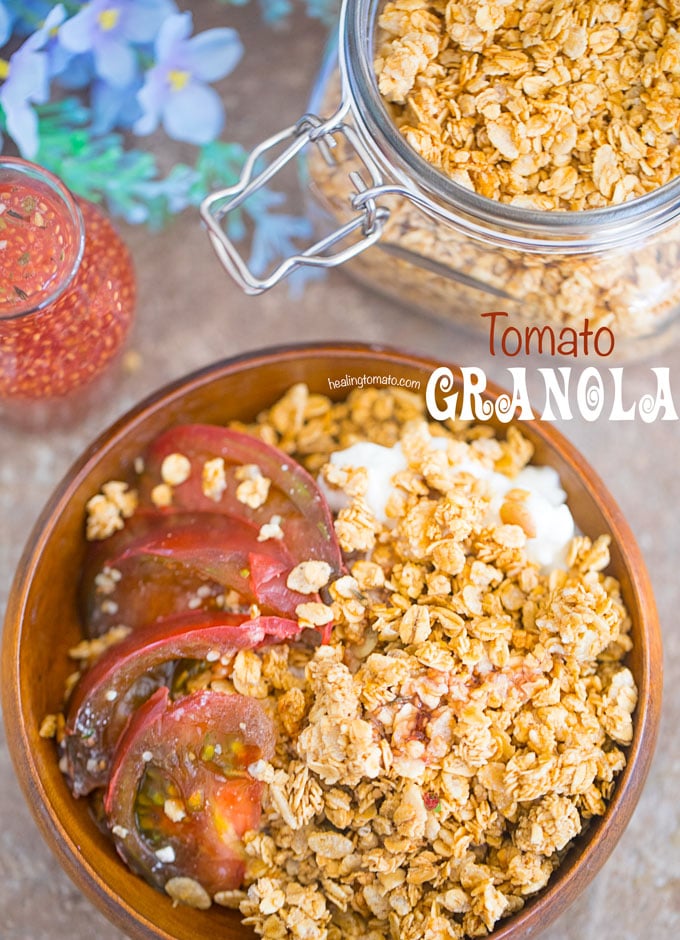 Overhead of a brown bowl filled with the tomato granola with the kombucha dressing in the glass bottle. A mason jar with the Granola is next to it