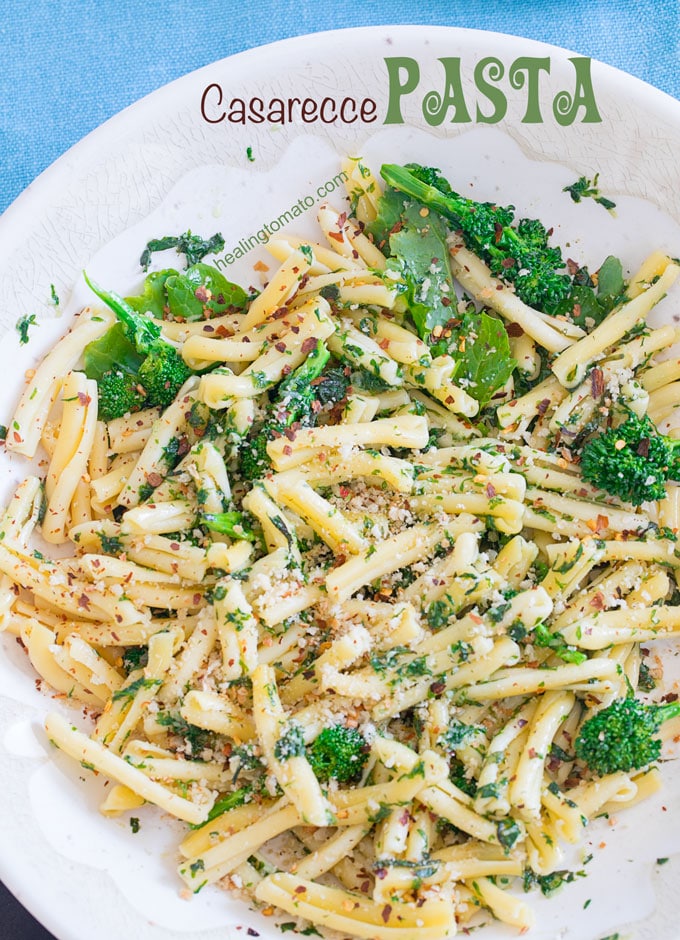 Overhead view of a white bowl filled with casarecce pasta, roasted broccolini, vegan butter sauce and panko bread crumbs as garnish