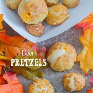 Overhead view of beer pretzel bites on a brown surface surrounded by fall leaves