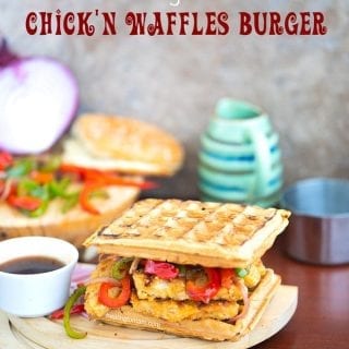 Angle view of a waffle burger with sauce on the side and grilled veggies in the back - Chickn and Waffle Burgers