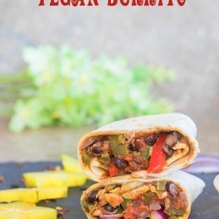 Front view of a Vegan Burrito cut into half and stacked. Surrounded by cut carambola