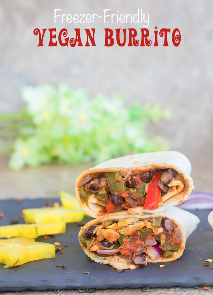 Front view of a Vegan Burrito cut into half and stacked. Surrounded by cut carambola