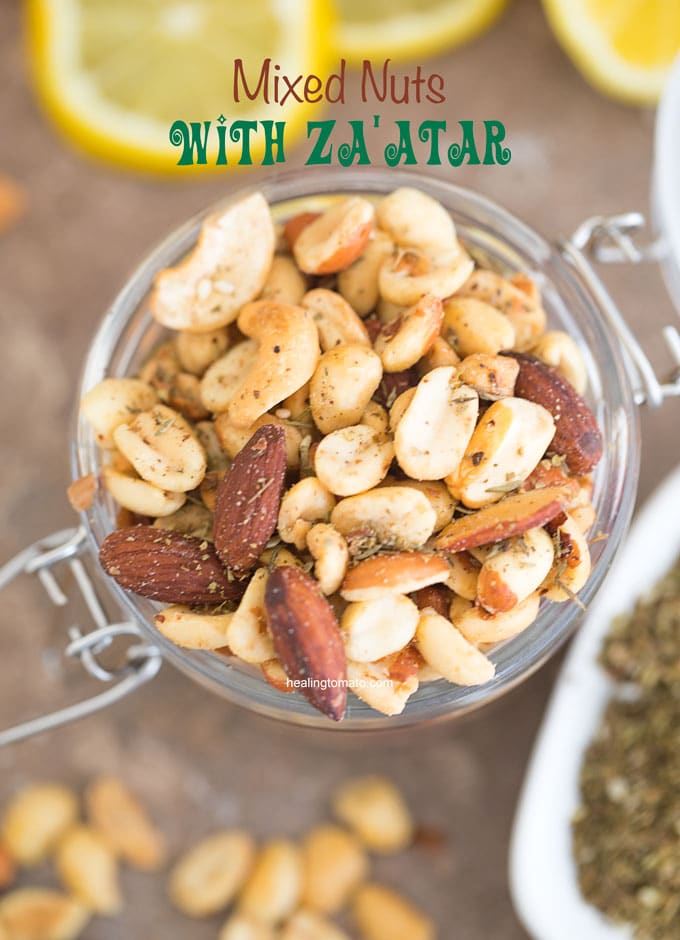 Overhead view of Mixed Nuts with Za'atar spice in a mason jar. Surrounded by za'atar spice and lemon rounds