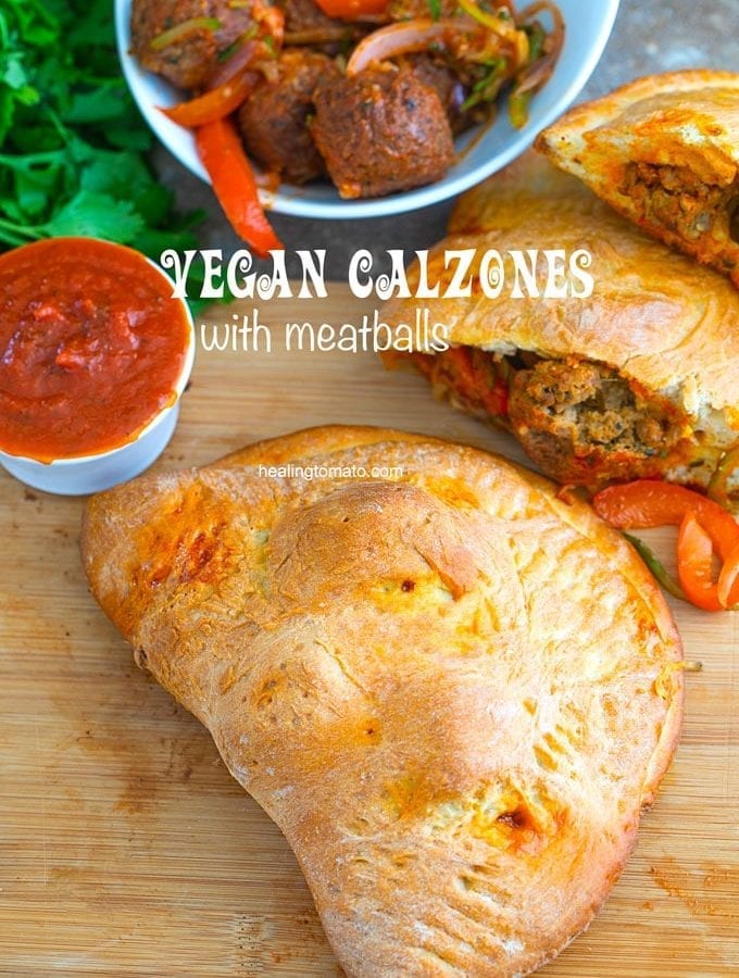 Overhead view of a whole vegan calzon. A side of sauce, cilantro and a pan filled with meatblalls are also visible