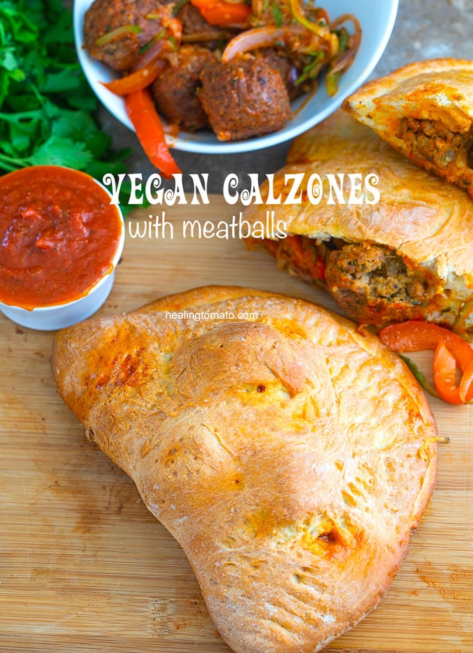 Overhead view of a whole vegan calzon. A side of sauce, cilantro and a pan filled with meatblalls are also visible