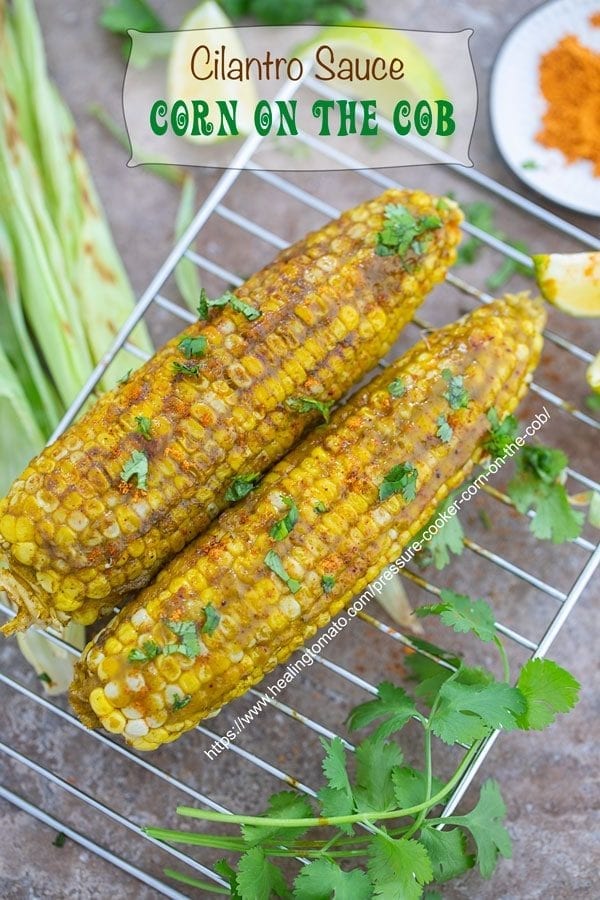 Overhead view of 2 Corn on the cob cooked and spread with a cilantro sauce