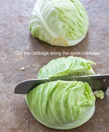 Halved cabbage being cut into quarters using a long knife - Cabbage Curry