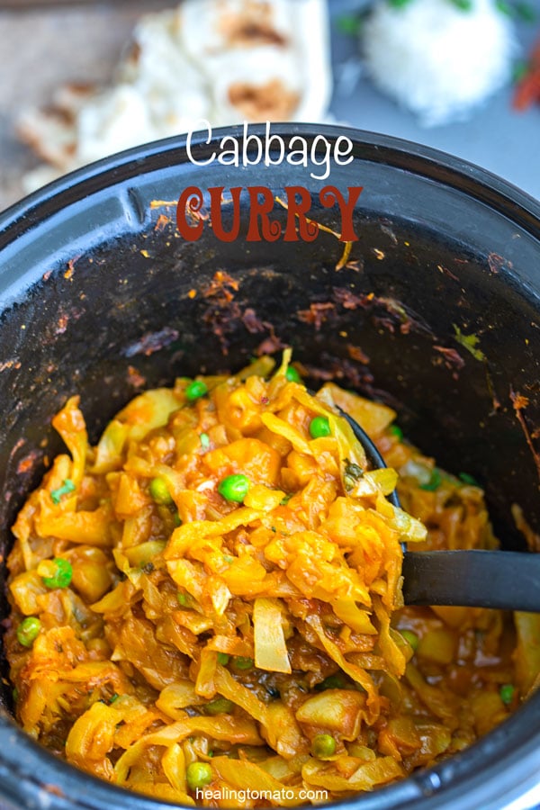 A ladel filled with the cabbage curry inside the slow cooker container filled with the vegan cabbage curry
