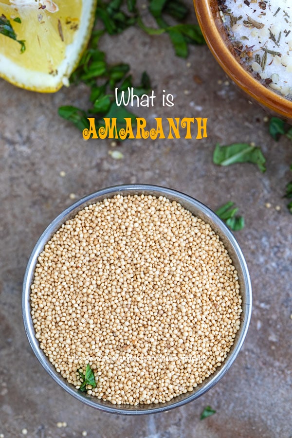 Overhead view of amaranth grains in a steel bowl. Lemon wedges and parsley surround it