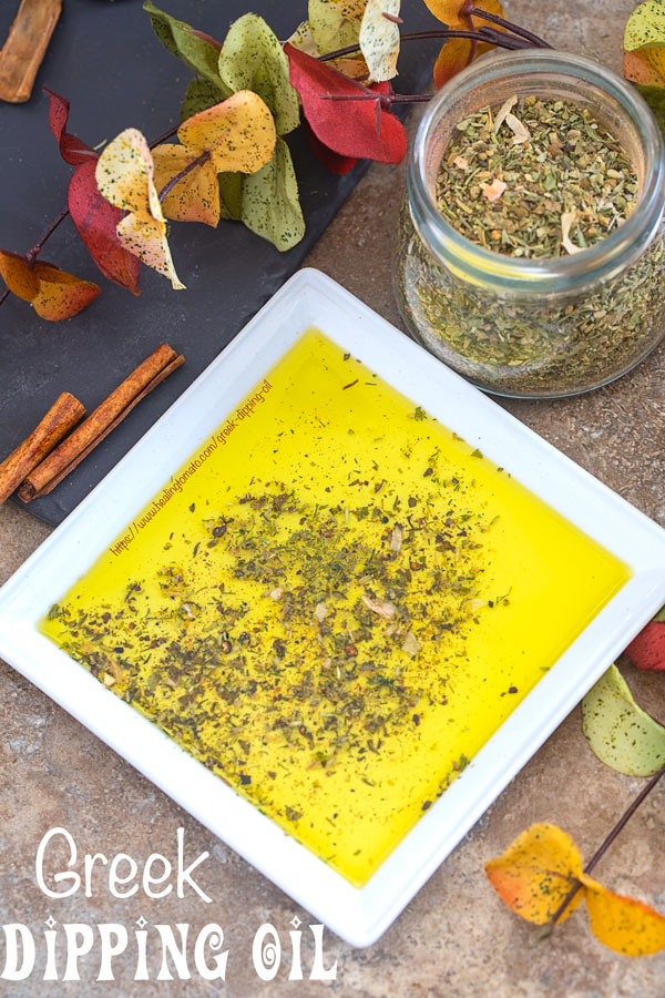 Overhead view of a white plate with Greek seasoning mix surrounded by Autumn leaves and a jar of Greek Seasoning mix 