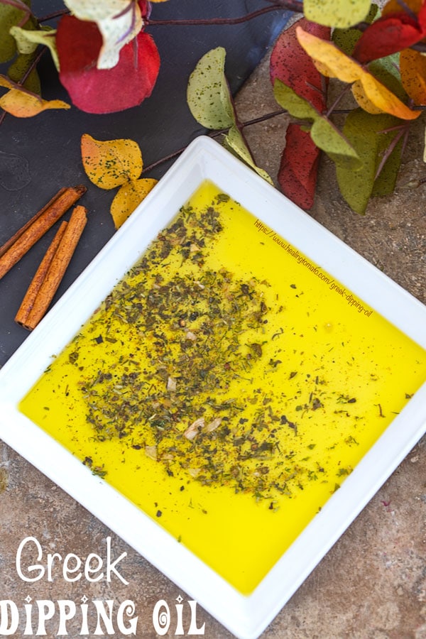 Overhead view of a white plate with Greek seasoning mix surrounded by Autumn leaves and a jar of Greek Seasoning mix 