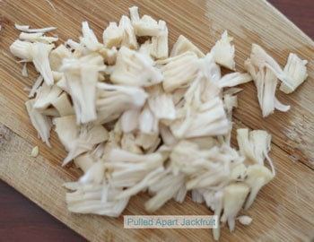 A pile of pulled apart jackfruit on a brown chopping board - Jackfruit Chowder