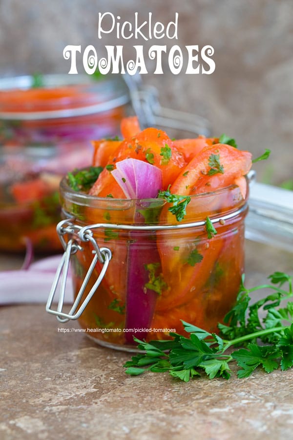 Front view of Pickled tomatoes in a mason jar and another jar in the background