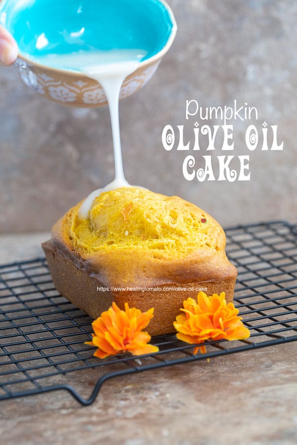 Front view of the icing being drizzled on the olive oil cake