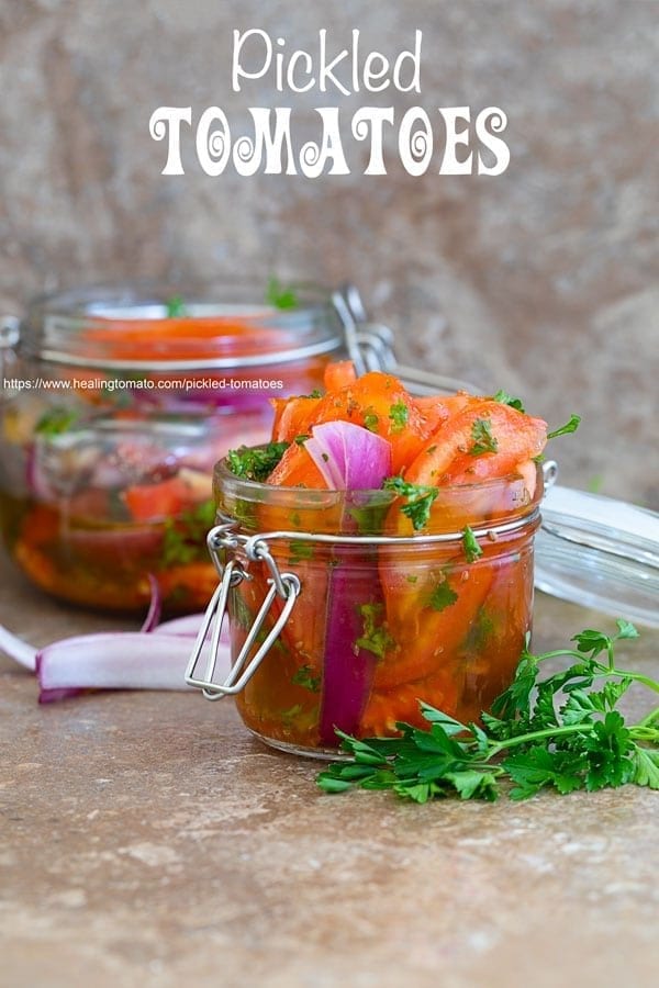 Front view of Pickled tomatoes in a mason jar and another jar in the background