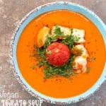 Overhead view of a blue bowl with cream tomato soup