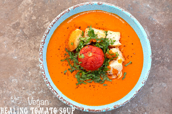 Overhead view of a blue bowl with cream tomato soup