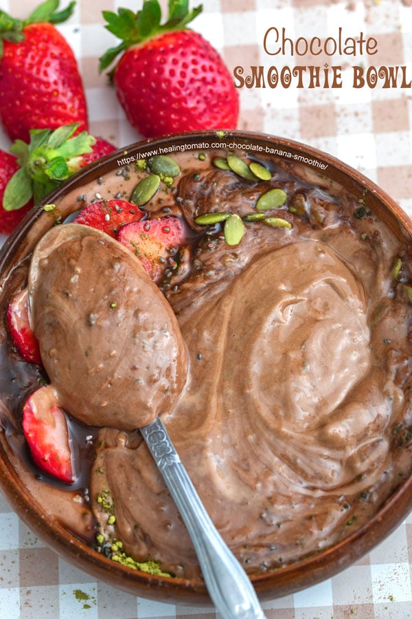 Top view of a spoon filled with chocolate banana smoothie in a bowl - 