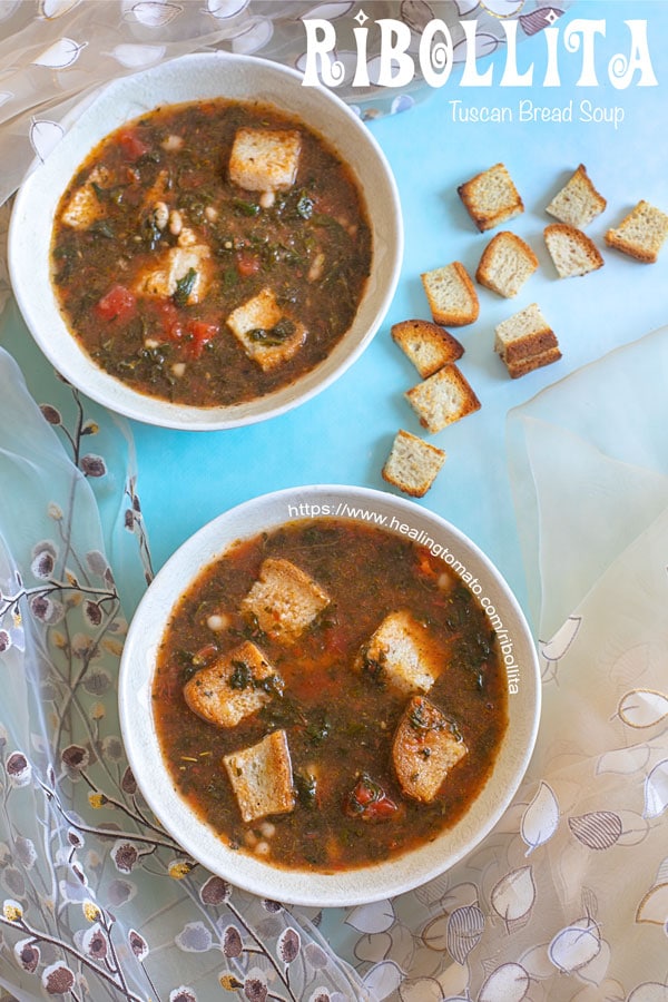 Overhead view of two bowls of ribollita with bread cubes on the side