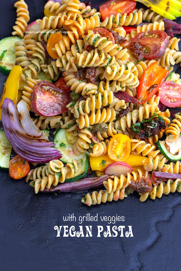 Overhead view of vegan pasta with grilled veggies on a black plate