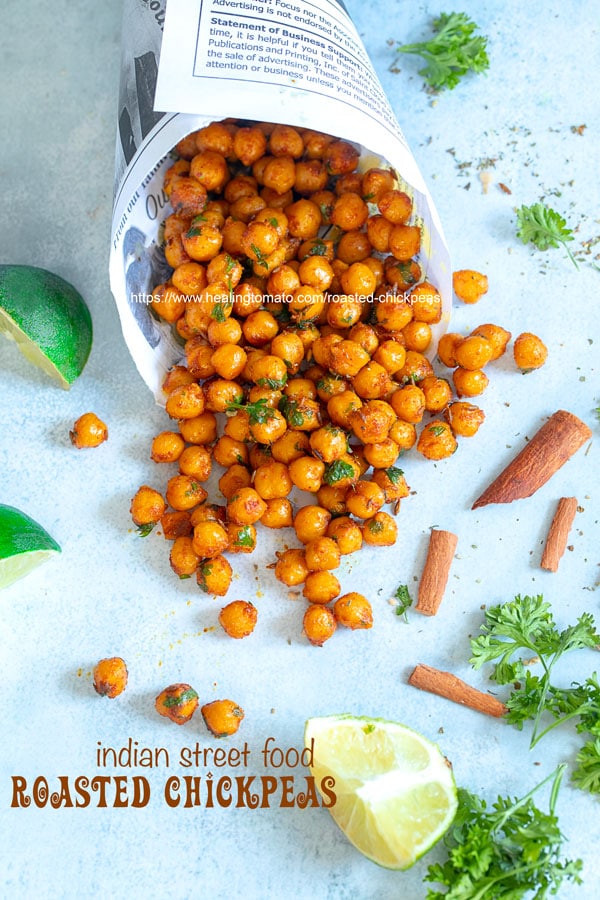 Overhead view of newspaper shaped in a cone laying flat with roasted chickpeas falling out of it