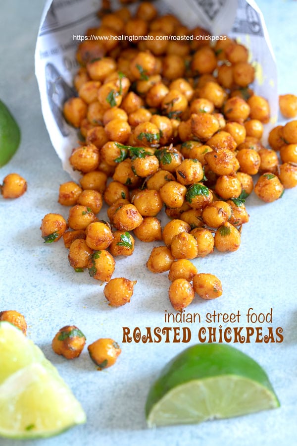 Overhead view of newspaper shaped in a cone laying flat with roasted chickpeas falling out of it - pan fired chickpeas