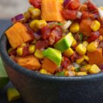 Front and cloesup view of sweet potato salsa in a black salsa bowl