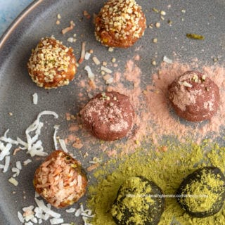 Close-up view of 7 no bake energy bites on a dark grey plate