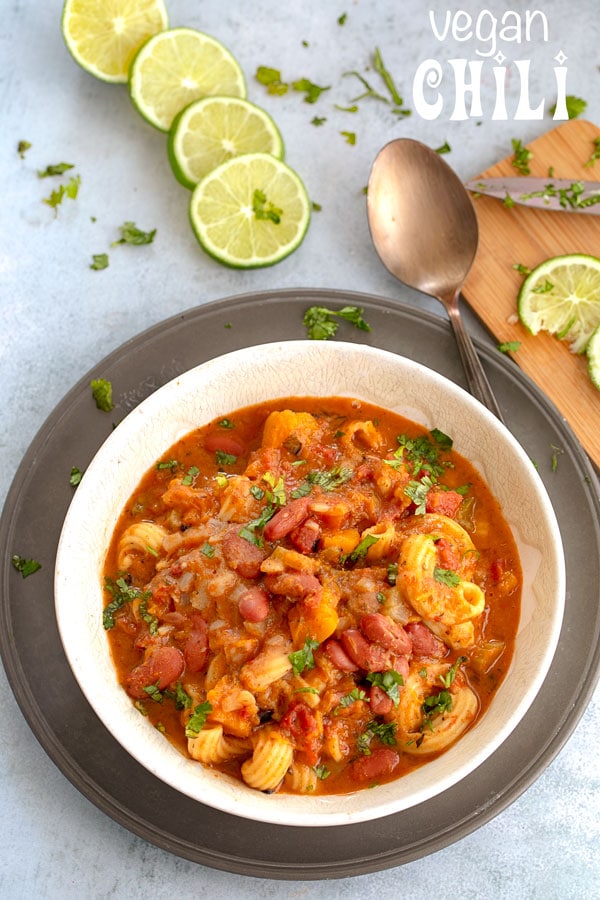 Top view of vegan chili in a bowl surrounded by lime slices