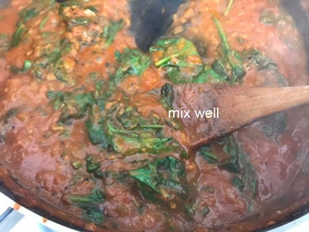 spinach being stirred into paneer Makhani