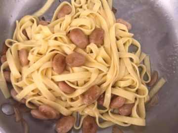 Top view of fettuccine pasta with butter beans in pan