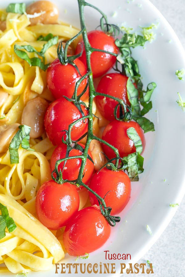 closeup view of cherry tomatoes on the vine on the pasta plate