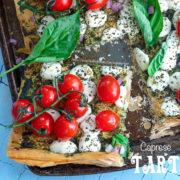 Top view of a square cut out of a phyllo dough caprese tart. Topped with tomatoes on the vine and mozzarella