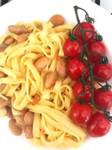 plated fettuccine Pasta with cherry tomatoes on the right side