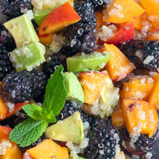 closeup view of quinoa fruit salad with a mint leaf garnish
