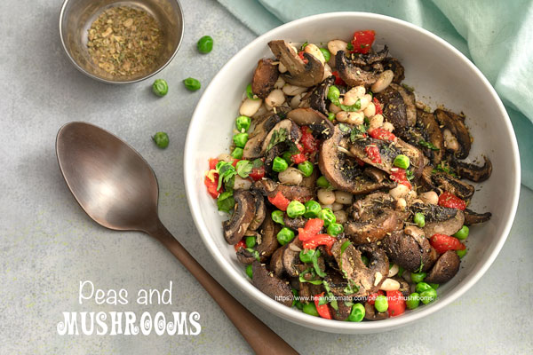 Top view of a white bowl filled with peas and mushrooms, navy beans and bell peppers