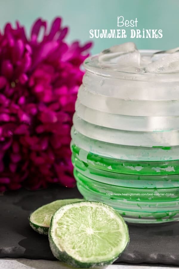 Front view of a green and white ridged glass filled with water and ice cubes - Best summer drinks